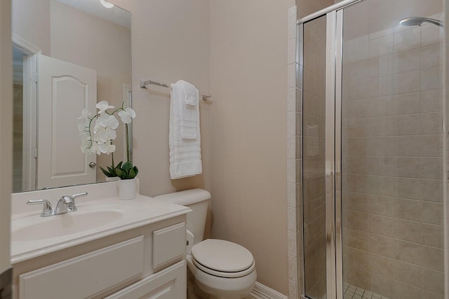 bathroom with a shower stall, toilet, and vanity