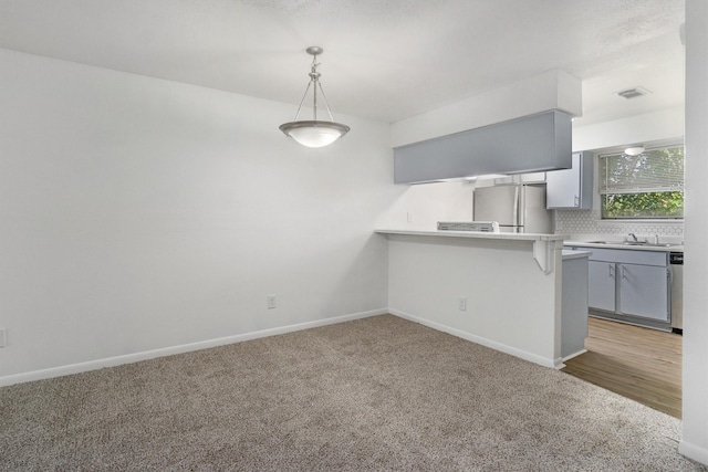 kitchen with a breakfast bar, gray cabinets, kitchen peninsula, and appliances with stainless steel finishes