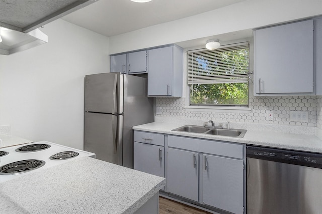 kitchen featuring sink, stainless steel appliances, dark hardwood / wood-style flooring, gray cabinets, and decorative backsplash