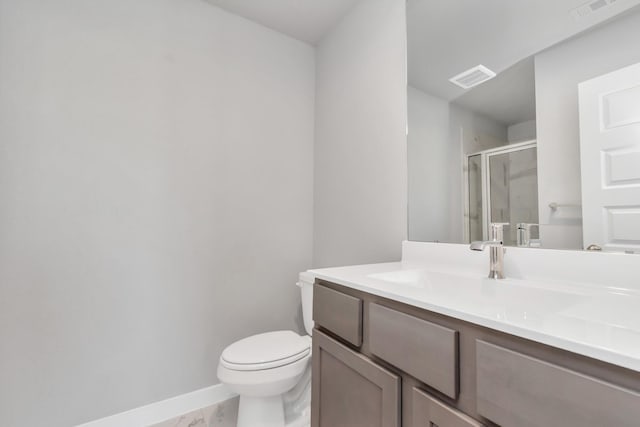 bathroom with vanity, toilet, and a shower with door