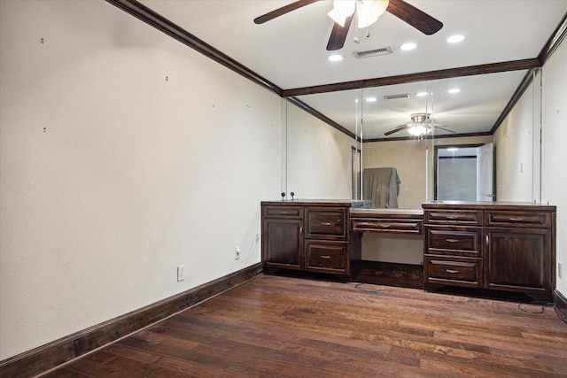 interior space with ceiling fan, dark hardwood / wood-style flooring, built in desk, and ornamental molding