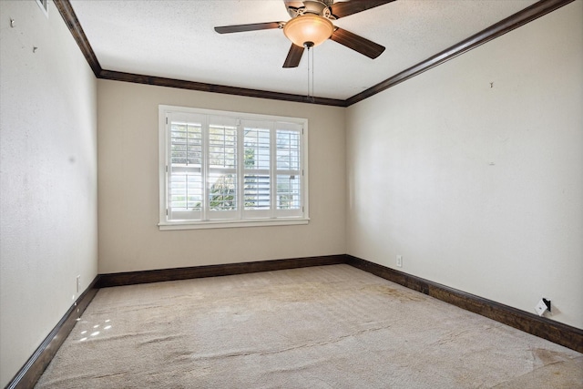 carpeted empty room featuring ceiling fan, crown molding, and a textured ceiling