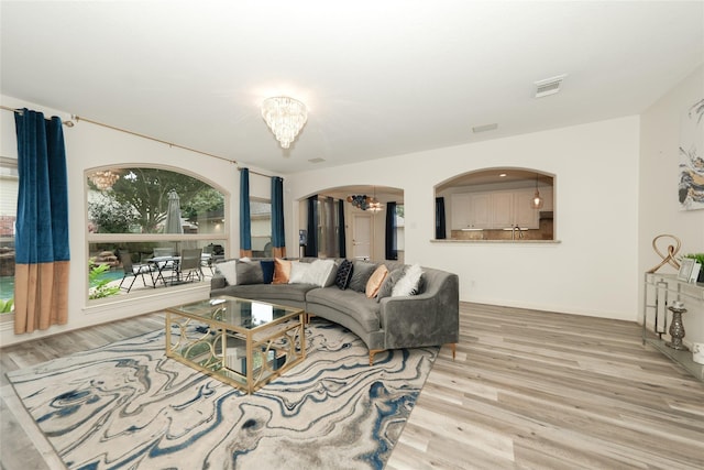 living room with a chandelier and light hardwood / wood-style floors