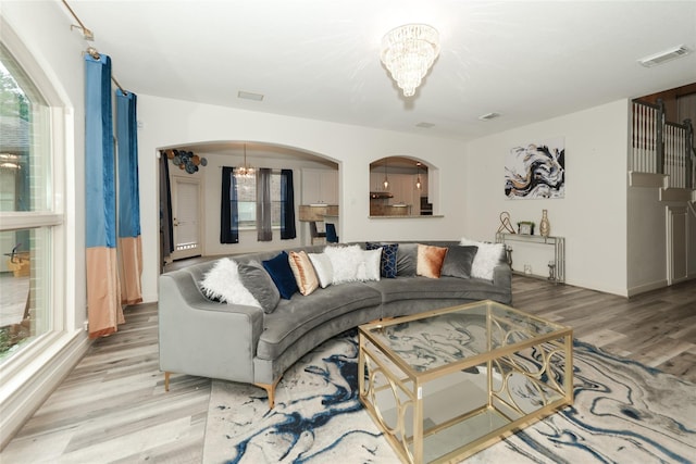 living room featuring a chandelier and light wood-type flooring