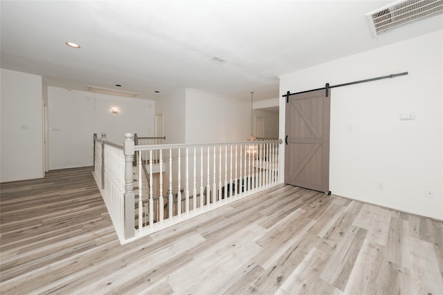 empty room with a barn door and light wood-type flooring