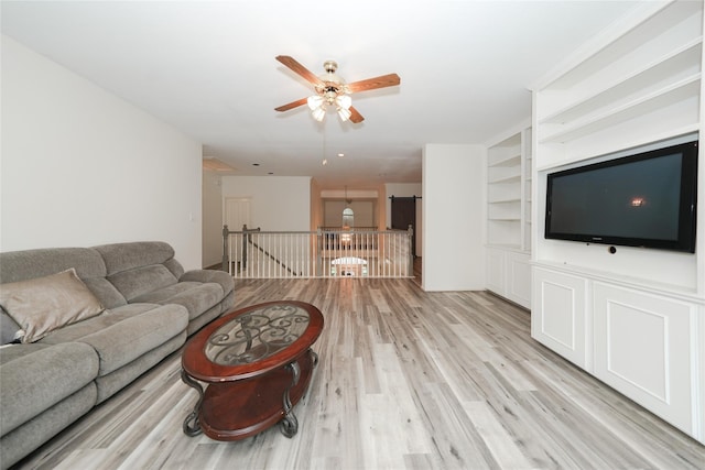 living room with ceiling fan, built in features, and light hardwood / wood-style flooring