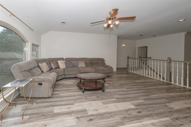 living room with light hardwood / wood-style floors, ceiling fan, and lofted ceiling