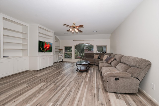 living room with hardwood / wood-style floors, ceiling fan, and built in shelves