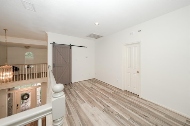 interior space featuring light wood-type flooring and a barn door