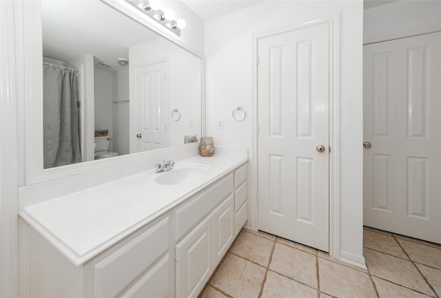 bathroom with tile patterned floors, vanity, and toilet