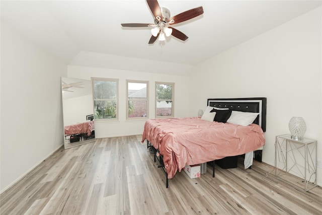 bedroom with ceiling fan, vaulted ceiling, and light hardwood / wood-style flooring