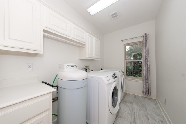 washroom with washing machine and clothes dryer and cabinets