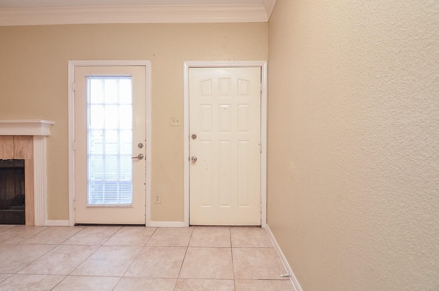 entryway with a tiled fireplace, crown molding, and light tile patterned floors