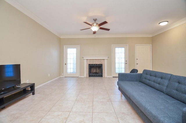 tiled living room with ceiling fan, ornamental molding, and a fireplace