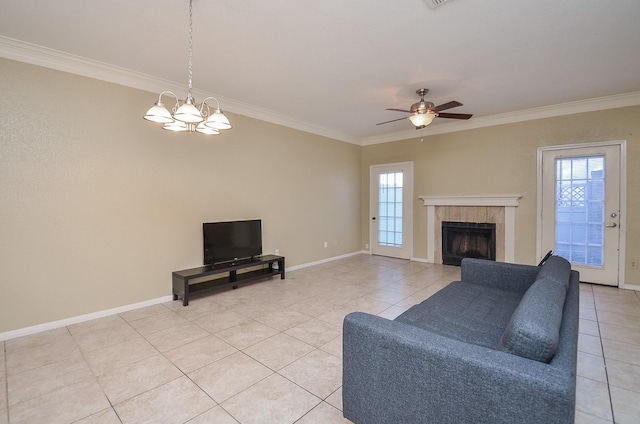 tiled living room with a tile fireplace, ceiling fan with notable chandelier, and ornamental molding