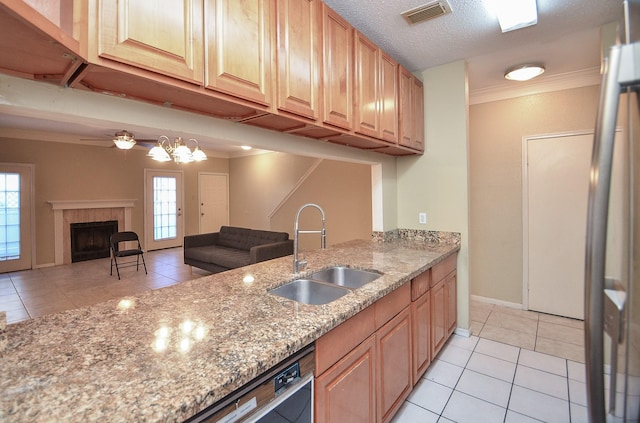 kitchen with a healthy amount of sunlight, ornamental molding, sink, and a tile fireplace