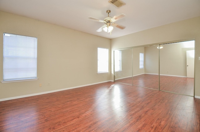 unfurnished bedroom featuring dark hardwood / wood-style flooring, a closet, and ceiling fan