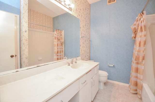 full bathroom featuring tile patterned floors, vanity, toilet, and shower / bath combo