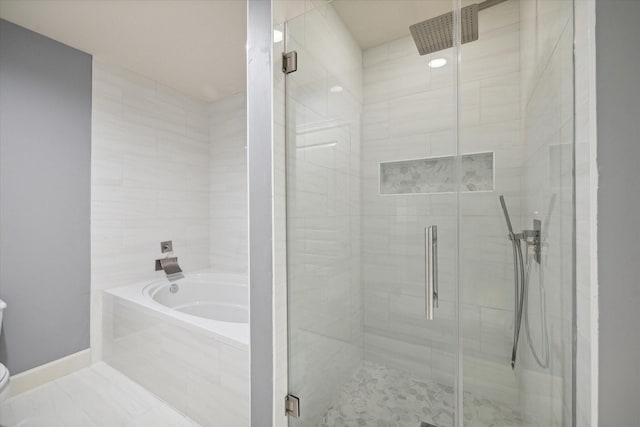 bathroom with toilet and shower with separate bathtub