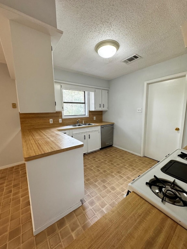 kitchen with kitchen peninsula, stainless steel dishwasher, sink, white cabinets, and white gas stove