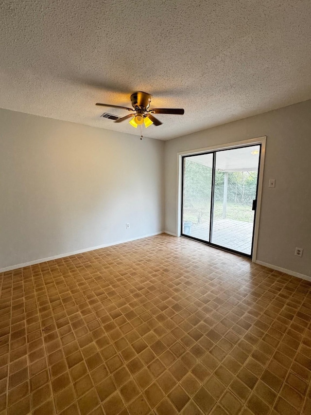 unfurnished room with ceiling fan and a textured ceiling