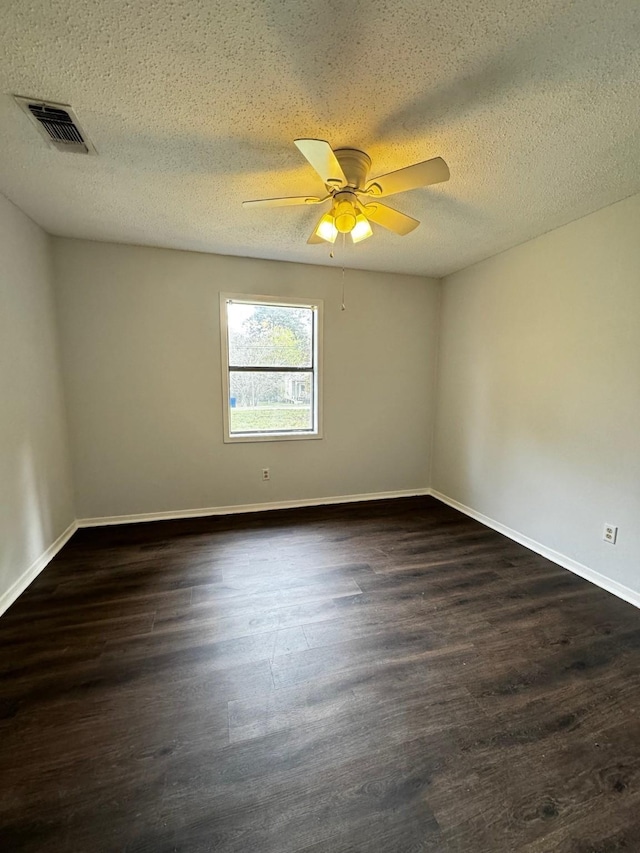 empty room with ceiling fan, dark hardwood / wood-style flooring, and a textured ceiling