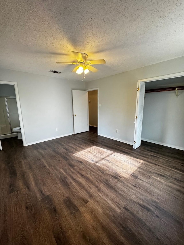 unfurnished bedroom with ceiling fan, a textured ceiling, and dark wood-type flooring