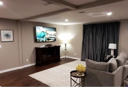 living room with beamed ceiling and dark wood-type flooring