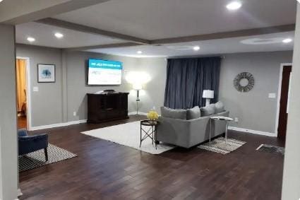 living room featuring beam ceiling and dark wood-type flooring