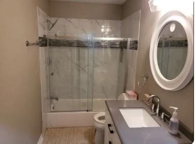 full bathroom with toilet, vanity, and combined bath / shower with glass door