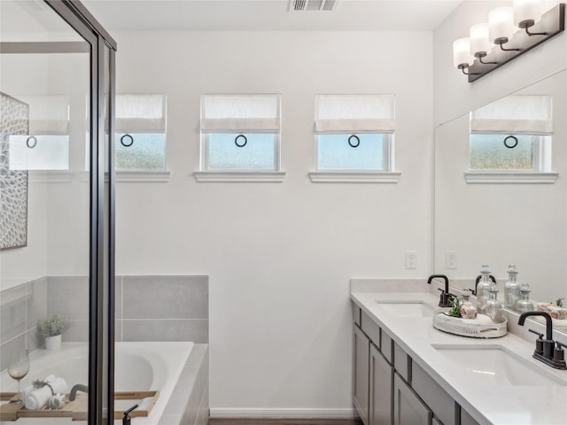 bathroom with separate shower and tub, plenty of natural light, and vanity