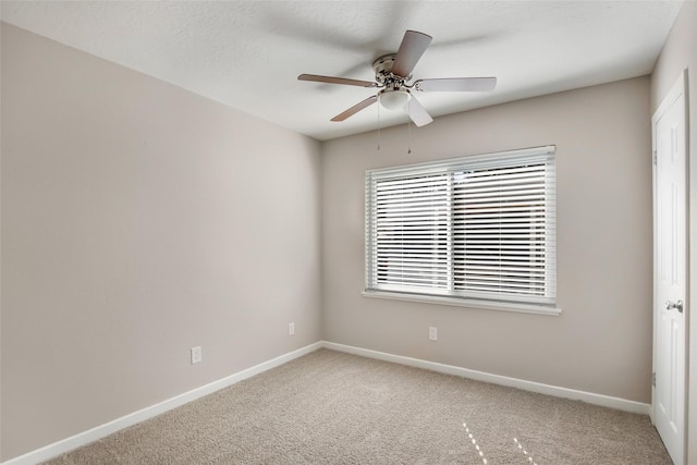 carpeted spare room with ceiling fan