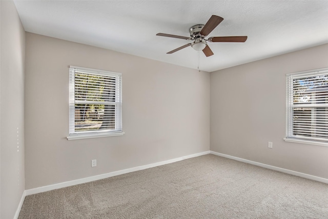 carpeted spare room with ceiling fan