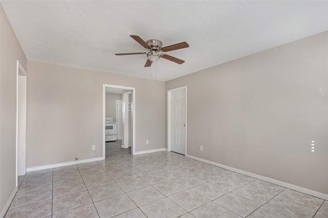 tiled empty room featuring ceiling fan and a textured ceiling