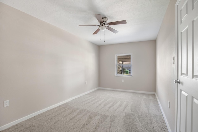 carpeted empty room featuring ceiling fan and a textured ceiling