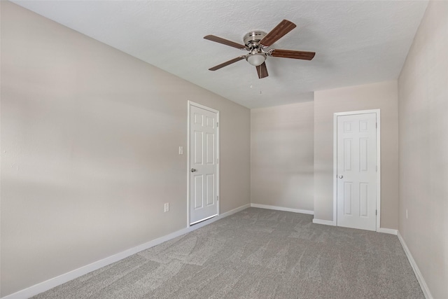 carpeted empty room featuring ceiling fan and a textured ceiling