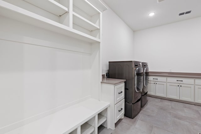 laundry area with cabinets and washing machine and clothes dryer