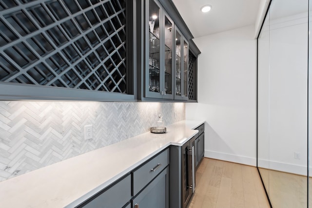 bar featuring decorative backsplash and light hardwood / wood-style flooring