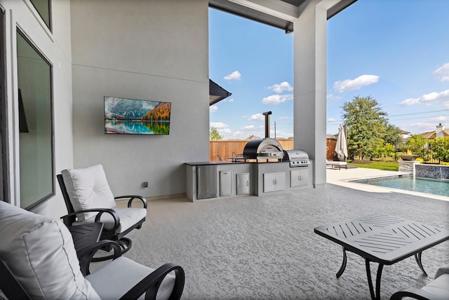 view of patio with pool water feature, a fenced in pool, grilling area, and exterior kitchen