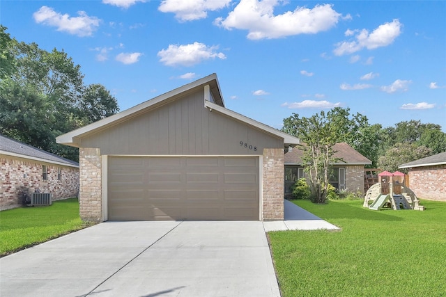 view of front of property with a garage, a playground, a front yard, and central air condition unit