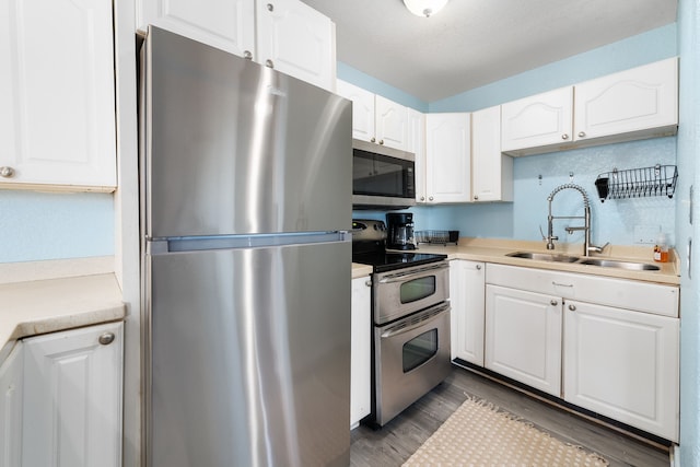 kitchen featuring white cabinetry, sink, stainless steel appliances, and dark hardwood / wood-style floors