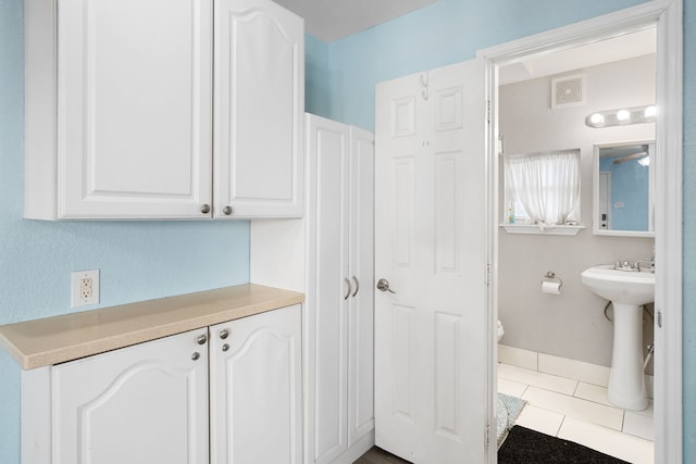 bathroom with tile patterned flooring, toilet, and sink