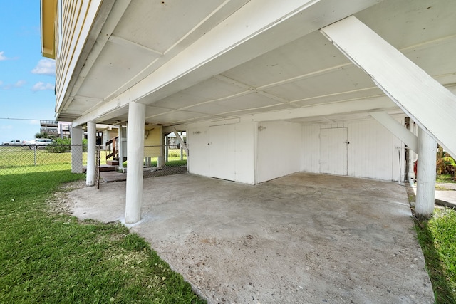 garage featuring a lawn and a carport