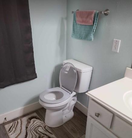 bathroom featuring wood-type flooring, vanity, and toilet