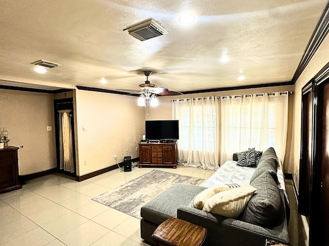 tiled living room with ceiling fan, ornamental molding, and a textured ceiling