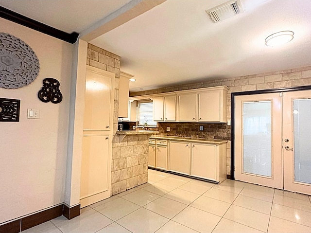 kitchen featuring white cabinets, light tile patterned floors, and french doors