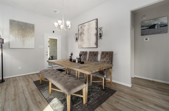 dining space with a chandelier and light hardwood / wood-style floors