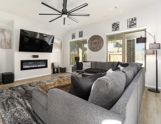 living room with ceiling fan, lofted ceiling, and light hardwood / wood-style flooring