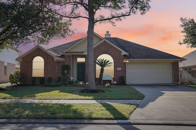 view of front of house with a yard and a garage