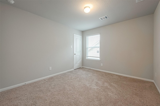 carpeted empty room featuring a textured ceiling